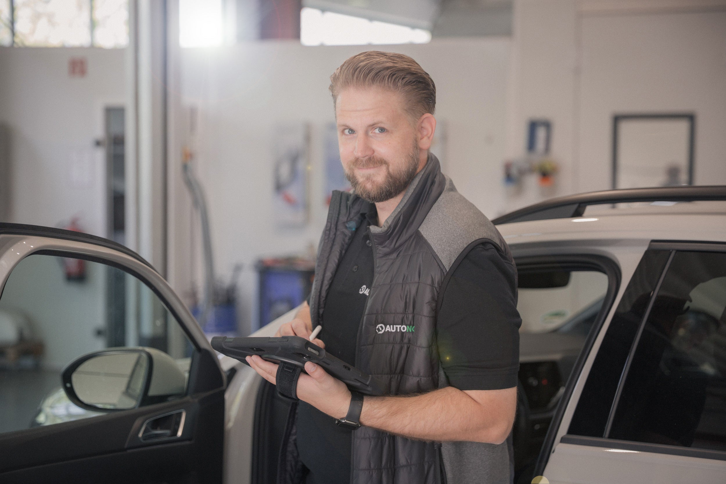 Lars Jacobi, Kfz-Sachverständiger von AUTONORM, bei der Fahrzeugaufnahme mit dem Tablet.