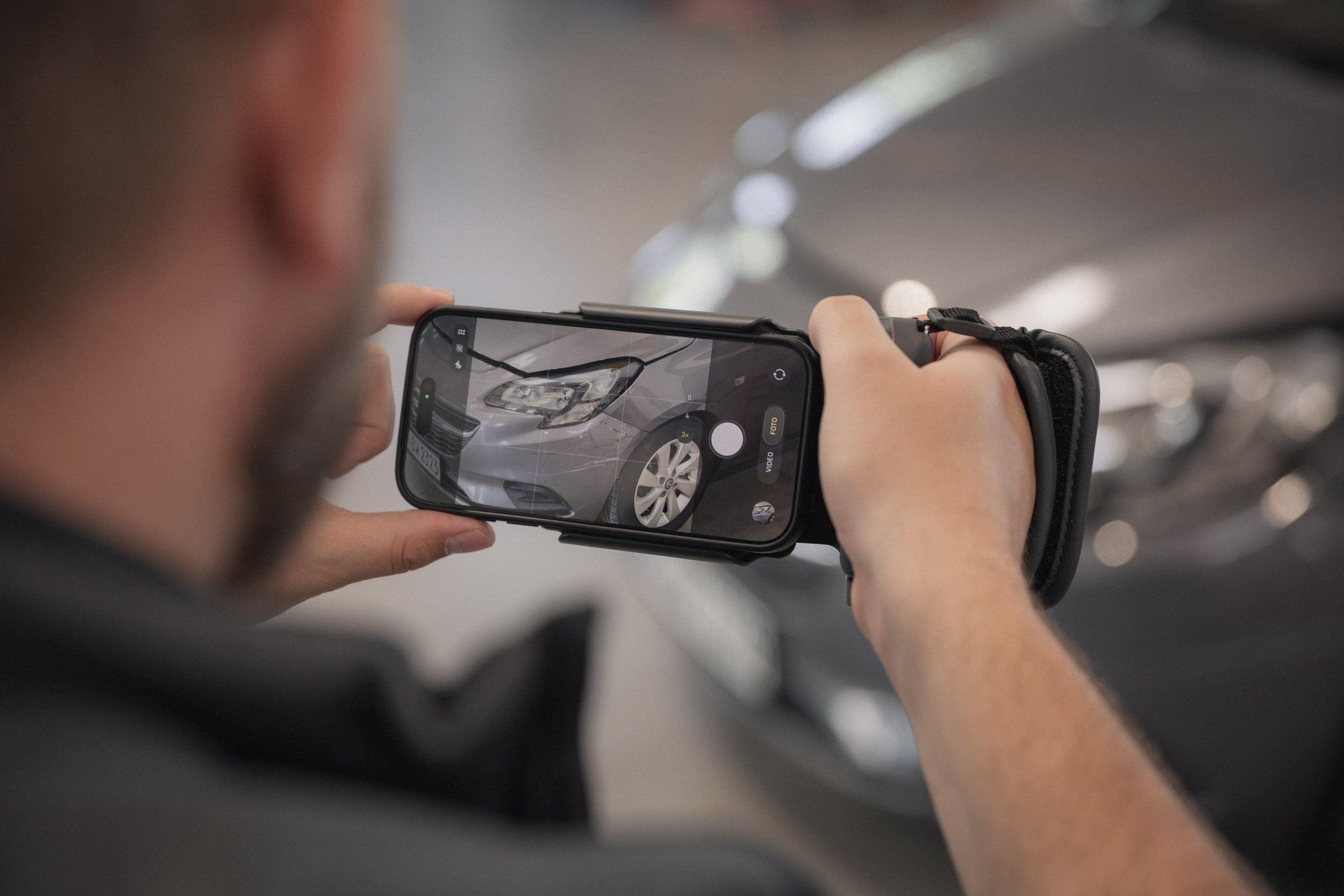 Lars Jacobi, Kfz-Sachverständiger von AUTONORM, macht mit einem professionellen Kamera-Rig ein Übersichtsfoto des Unfallschadens vorne links am Fahrzeug.